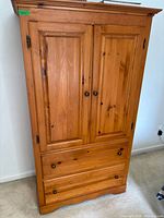 Front view of entire armoire showing paneled doors and drawers