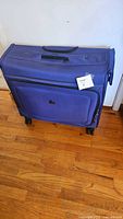 Front view of blue Delsey rolling garment suitcase