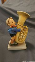 Full view of Goebel boy with tuba figurine on square base