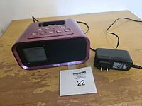 Front view showing display, speaker grille and AC adapter