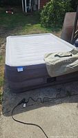Inflated Intex queen raised air mattress with storage bag and electric pump visible