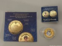 Display card showing coin details including 24k gold plating, date of birth, and historic imagery