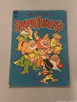 Front cover of 1949 Walt Disney's Seven Dwarfs comic book showing the seven dwarfs in colorful illustration with title text on a blue background.