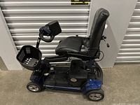 Side profile of blue mobility scooter with black seat and front basket