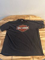Full view of black Harley-Davidson t-shirt laid flat showing front logo.