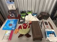 Full lot overview showing various office supplies, toys, decorative items, and electronics placed on a brown surface.