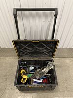 Photo of a black rolling toolbox open, showing assorted tools and equipment inside.
