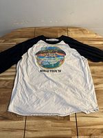 Full front view of vintage Boston World Tour '79 T-shirt with black raglan sleeves on white body.