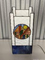 Front view of the rectangular stained glass lamp with white, blue, and colorful geometric panel design.