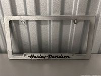 Metal license plate frame with Harley-Davidson logo in black text at the base.