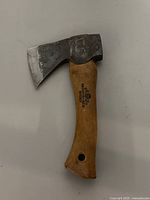 Full view of the vintage hatchet with steel head and wooden handle.