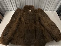 Full view of brown rabbit fur jacket showing plush fur and overall condition.