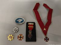 Full view of entire collection showing all six Masonic badges and pins on a flat surface.