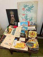 Overview of wood end table with collectibles and travel brochures on top including pamphlets and stickers