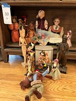 Overview of the international dolls collection on wooden furniture shelf and surface