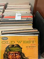 Photo of vinyl LP records showing 'Songs of the Old West' by Ed McCurdy album cover in front.