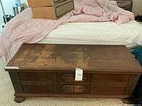 Full top-down view of the cedar chest showing overall size, flat top surface with visible wear, and carved front.