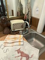 Silvertone vintage radio next to the wooden carved owl, fabric towels, and candles on a countertop.
