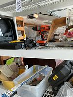 Black & Decker cordless drill, assorted repair items, gloves, tools and zip ties on shelf
