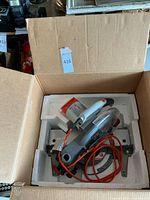 Rigid 10 inch compound miter saw inside original packaging box with attached orange power cord and visible blade guard.
