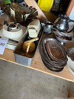 Photo showing silver plated serving pieces including teapot, creamer, sugar bowl, gravy boat, and trays along with vintage electric utensil sharpener and blender base.