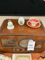 Wooden Silvertone radio with cup, saucer, egg, and bell on top