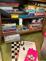 Shelves filled with a mix of board games, puzzles, and card games including vintage packaging of products from the 1970s-1980s era.