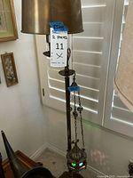 Full view of the vintage metal standing lamp with lampshade and hanging lantern attached by chains; shows the general scale and condition.