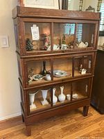 Full front view of the bookcase showing three stacked glass-fronted cabinets