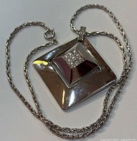 Angled front view of square pendant and chain