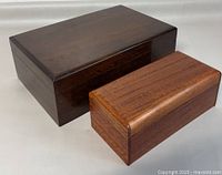 Two wooden boxes, one larger dark wood, one smaller lighter wood, placed side by side.
