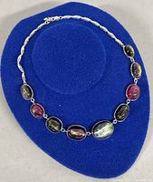 Full view of the 15 inch 925 sterling silver necklace with colorful oval gemstones arranged in a chain.
