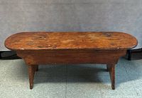 Full front view of bench showing overall form, rounded ends and splayed legs