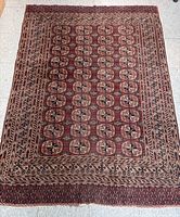 Full top view of the antique handwoven Turkman Bukhara rug showing the repeating octagonal gul motifs and detailed borders.