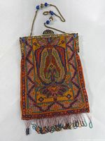 Full front view of rectangular micro-bead purse showing geometric floral pattern and beaded fringe