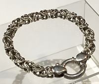 Close-up photo of the silver link design and clasp, showing detail and markings.