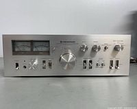 Front view of amplifier showing dual VU meters, controls and headphone jack