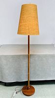 Full view of teak floor lamp with shade attached
