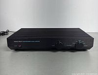 Front panel angled view showing red power switch, volume and selector knobs