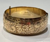Front view of the bangle displaying engraved floral patterns.