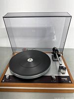 Full view of Thorens TD 160 turntable in wooden plinth with clear dust cover closed.