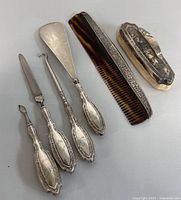 Top view of full 6-piece sterling silver grooming set with comb and clothes brush visible