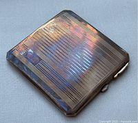 Front angled view of the vintage Birks sterling silver powder compact showing the geometric linear pattern and logo.