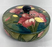 Top view of the lidded bowl showing floral painted lid with black knob handle.