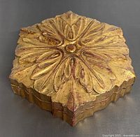 Top side view of vintage carved wood box showing ornate carved floral motif with gold and red paint finish.