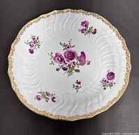 Top view of vintage Meissen floral porcelain plate showing scalloped edge and gold decorative rim.