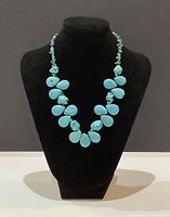 Necklace displayed on black bust showing full length and bead arrangement