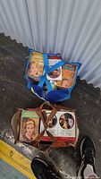 Two bags containing over 100 Harlequin romance books with visible colorful illustrated covers.