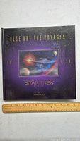 Front cover of the hardcover 'These Are the Voyages... 1987-1994' Star Trek 3D album. Shows the book cover with title and author Charles Curtis, alongside a ruler for scale.