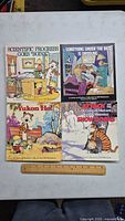 Front covers of four Calvin and Hobbes hardcover books showing colorful illustrated comic scenes and titles.